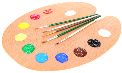 Wooden art palette with paint and brushes isolated on white