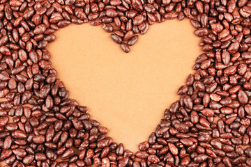 Heart of sunflower grains in chocolate, on brown background