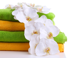 Colorful towels and orchid flowers, isolated on white
