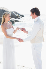 Man placing ring on pretty brides finger