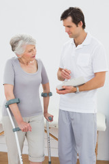 Fototapeta premium Therapist discussing reports with a disabled senior patient