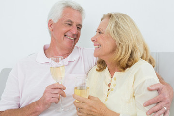 Senior couple with champagne flutes at home