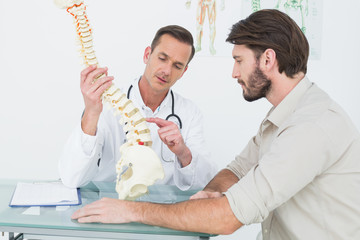 Male doctor explaining the spine to a patient