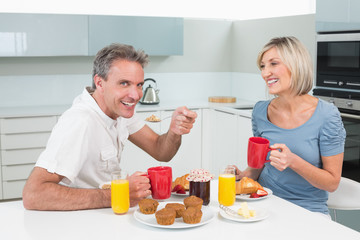 Obraz na płótnie Canvas Happy couple having breakfast in kitchen