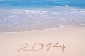 Year 2014 written in sand on tropical beach . 