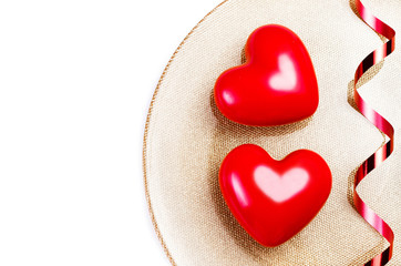 Two Big Red hearts on a golden plate isolated on white with fest