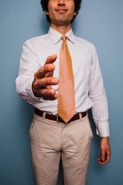 Young man in shirt and tie offering handshake