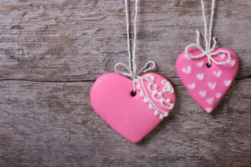 two pink hearts sweet cookies on a wooden boards background
