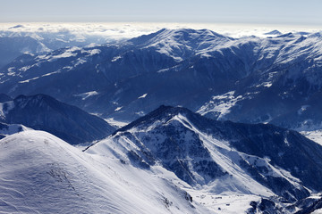 Snowy mountains and off-piste slope in morning haze