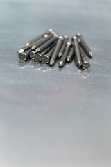 Group of steel nails on a metal work surface