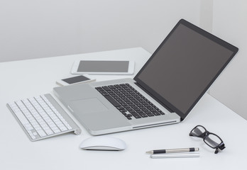 Laptop computer and tablet on white table