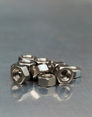 Steel nuts on a metal work bench