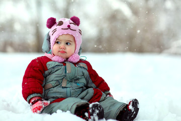 little girl sitting in the snow