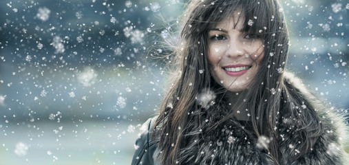 Beautiful young woman in a winter snow day
