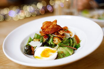 bacon and egg salad in large plate on table