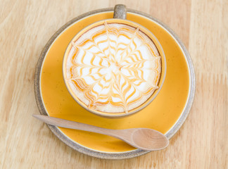 A Latte Coffee art on the wooden desk.