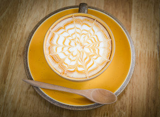 A Latte Coffee art on the wooden desk.