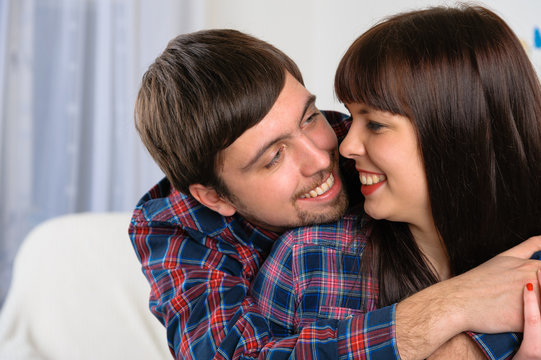 Portrait of happy young couple smiling to each other