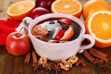 Fragrant mulled wine in pan on wooden table close-up
