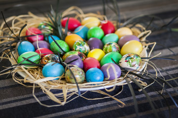 Bunch of colorful Easter eggs in a straw basket