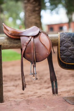 Horse saddle hanging on a wooden stand
