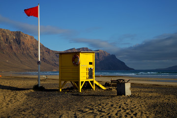 lifeguard chair red flag in spain   pond  coastline and summer