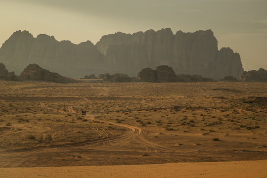 Mountains in Wadi Rum desert with desert road and small car