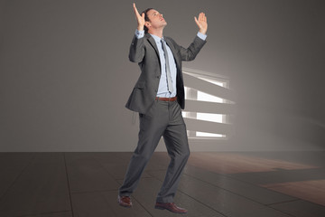 Composite image of businessman posing with arms raised
