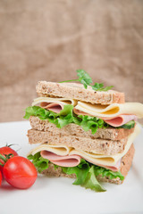 Fresh ham and cheese on white sandwich in rustic kitchen setting