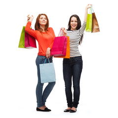 two smiling teenage girls with shopping bags