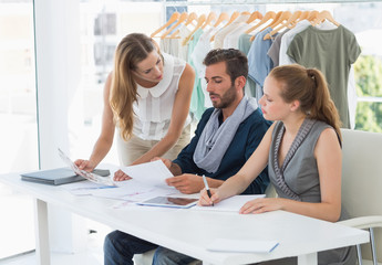 Fototapeta premium Three fashion designers discussing designs
