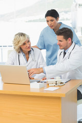 Fototapeta premium Doctors using laptop together at the medical office