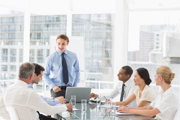 Businessman standing in front of his team at meeting