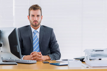 Obraz premium Serious businessman with computer at office desk
