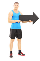 Male athlete holding a big black arrow pointing right