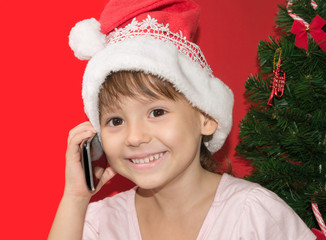 girl in Santa hat talking by the phone