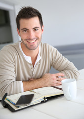 Fototapeta premium Young man with agenda working from home