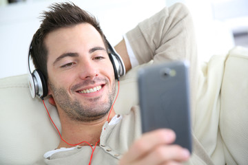 Young man relaxing in sofa with headphones on