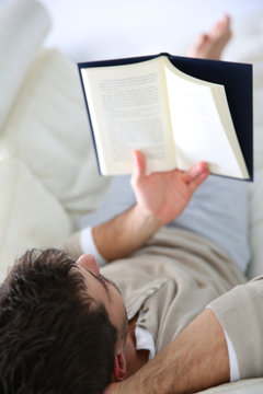 Man in sofa reading book