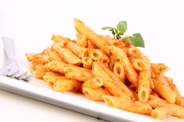 Pasta with pesto rosso being decorated with cress