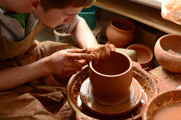 hands of a potter, creating an earthen jar on the circle