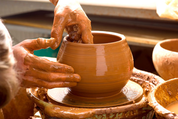 hands of a potter, creating an earthen jar