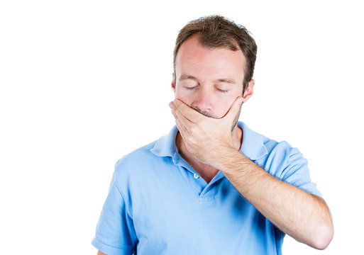 Man covering his closed mouth, speak no evil