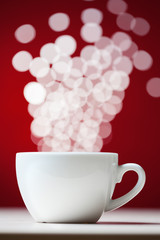 Fototapeta na wymiar Defocused lights as aroma emanates from white coffee cup