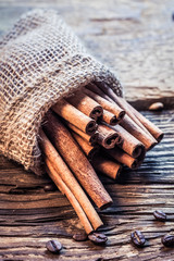 Cinnamon sticks in a burlap sack on the wooden table
