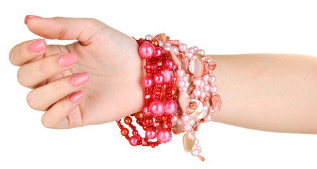 Female hand with pink manicure and bright bracelets, isolated