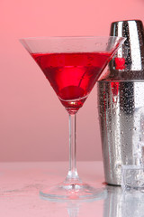 Cocktail shaker and cocktail on red background