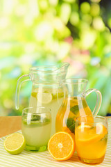 Orange and lemon lemonade in pitchers and glasses