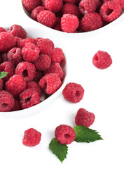 Ripe sweet raspberries in bowls, isolated on white