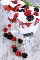 Natural yogurt with fresh berries on wooden background